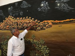 Ally Coe pointing at the stars as painted by Darren Cooper in his mural in the Wiradjuri Study Centre’s art room. Photo by Merrill Findlay.