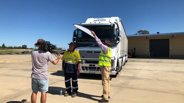 Andrew Barnes (on the camera), Ray Smith from Western Freight Management (the talent) and Transport for NSW Heavy Vehicle Inspector Peter McGlynn (providing the shade) filming the general freight how to video. The ‘Load Restraint Education Project’ has been heralded a success, meeting both its objectives. Image Contributed.