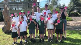 One student from each year holding a $100 Coles gift voucher with the school’s Principal, Kelly Jesser (back row - right)
