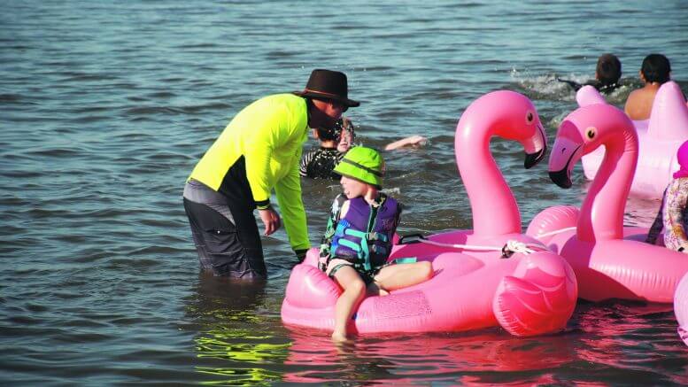 Familes had fun in the Lake with inflatable flamingos.