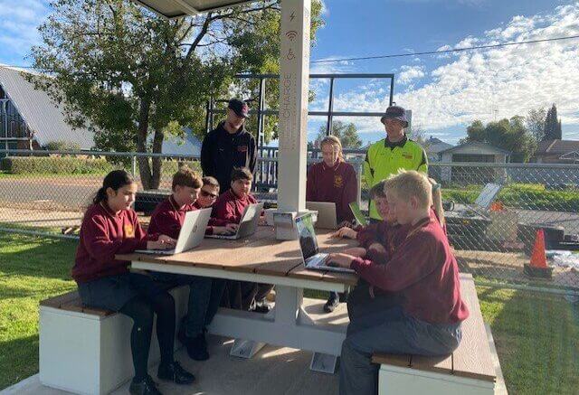 Students trying out the solar station for the first time. Four devices can charge simultaneously, and everyone can connect to WiFi whilst working at the station.