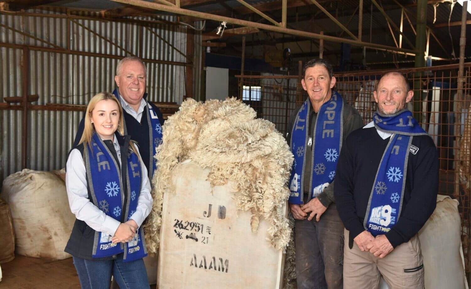 Genevieve Dyson, Mark Dyson and Craig Davis (Quality Wool) in the shearing shed with Ungarie farmer and Quality Wool client Chris Daniher (second from right), promoting FightMND’s new wool scarf. Image Credit: Lorraine Williams.